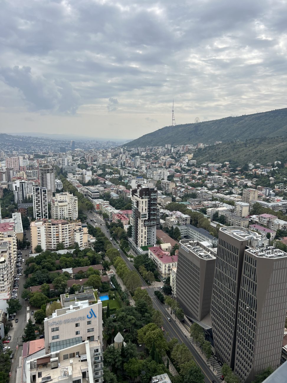 Вид с Axis Towers на телевышку и колесо обозрения на горе Мтацминда